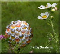 a mini gazing ball made from a rubber ball and flat sided marbles/gems at craftygardener.ca